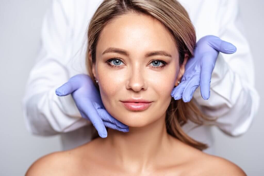 Facial Aesthetics: How To Do It Safely Aesthetician wearing blue gloves showing the facial treatment of a beautiful woman