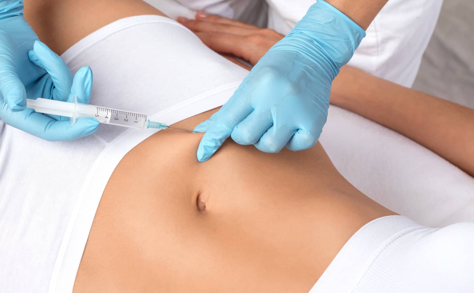 cosmetologist injecting Aqualyx into clients stomach