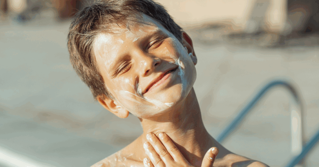 An image of a boy at the beach with mineral-based sunscreen on his face