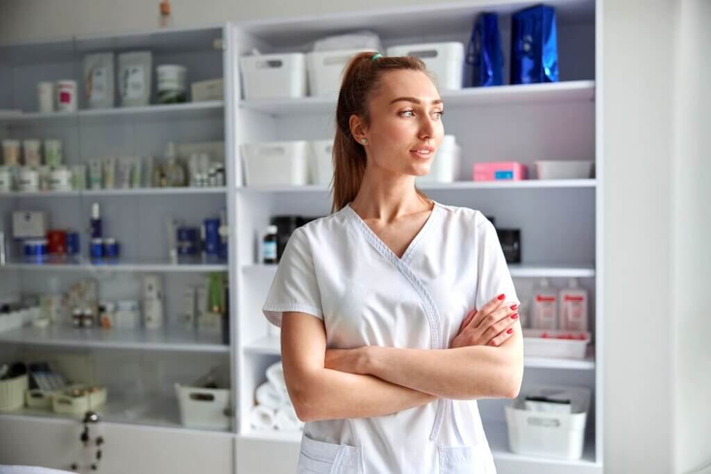 Female aesthetician folding arms