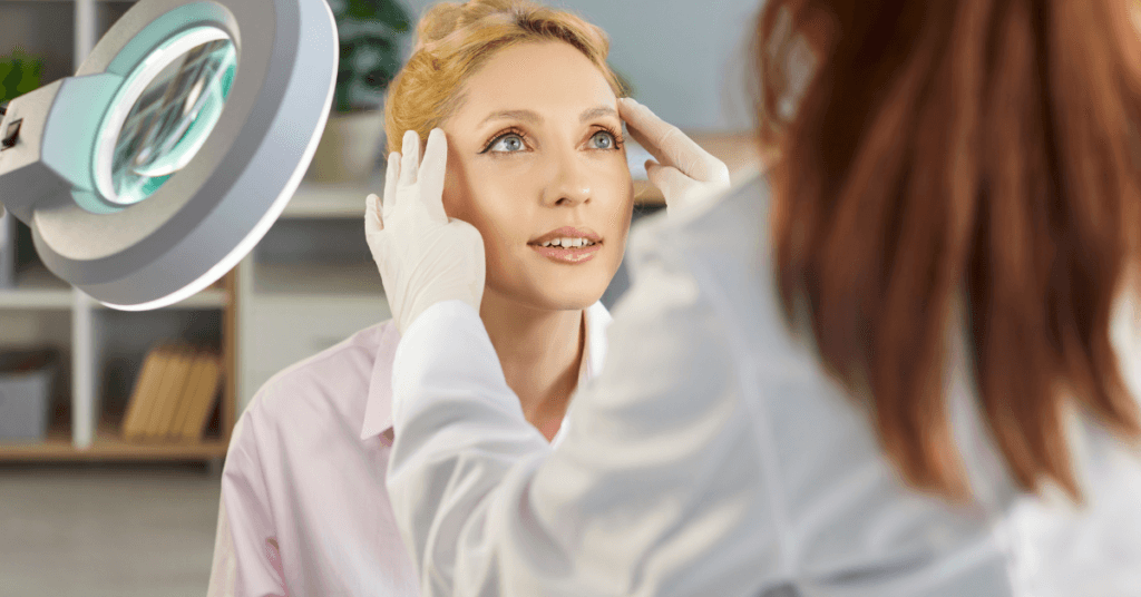 image of a woman having her face/skin assessed by an aesthetician for an article about Fulham Health clinic, and how they can help you reach your aesthetic goals.