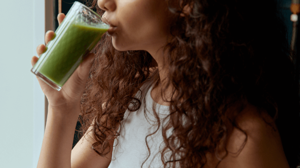 Image of a woman drinking green juice