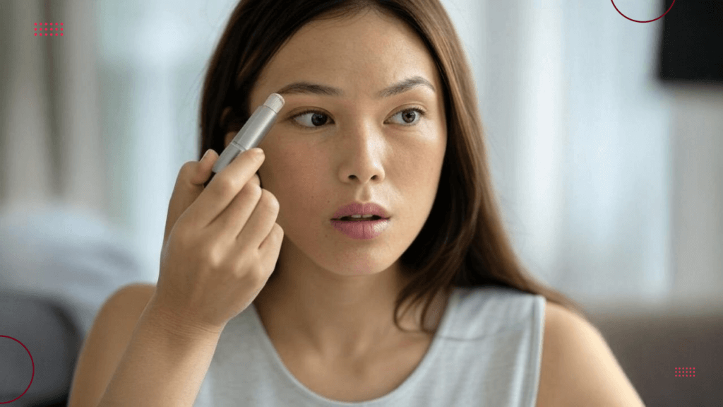 A lady applying lip balm to her brows