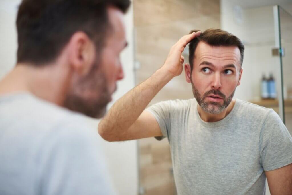 Middle aged man looking worried about losing hair