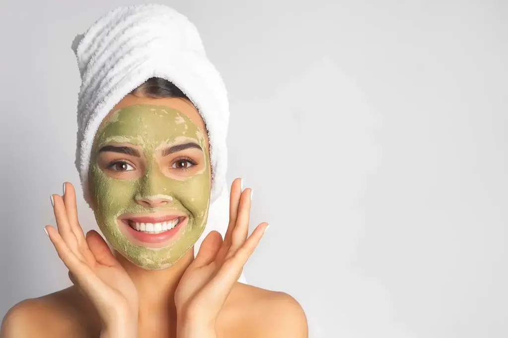 A woman showing off her homemade Soothe Irritating Skin Face Mask on her face