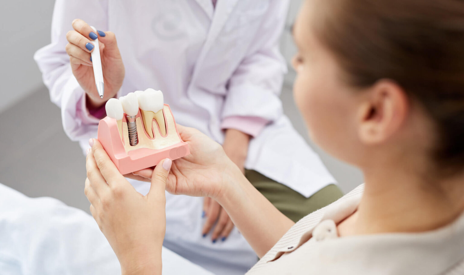 Woman holding dental implant model