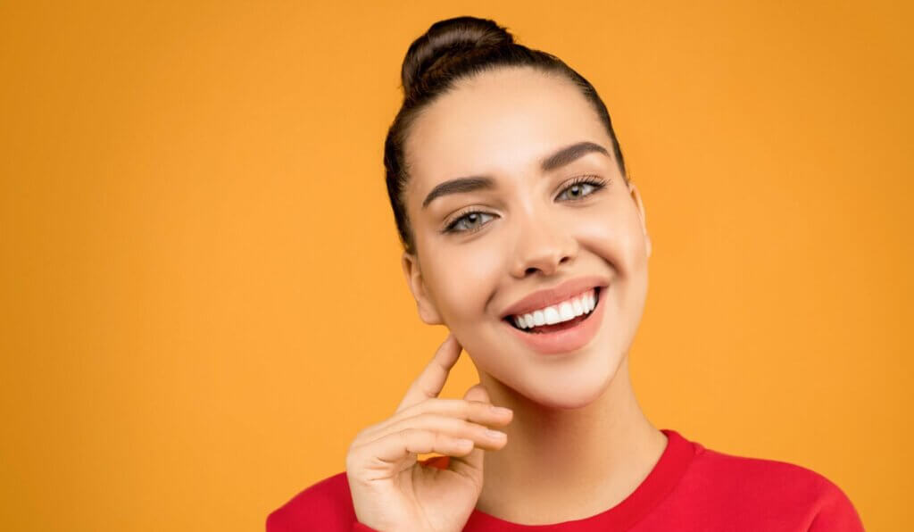 Woman in red sweatshirt touching skin