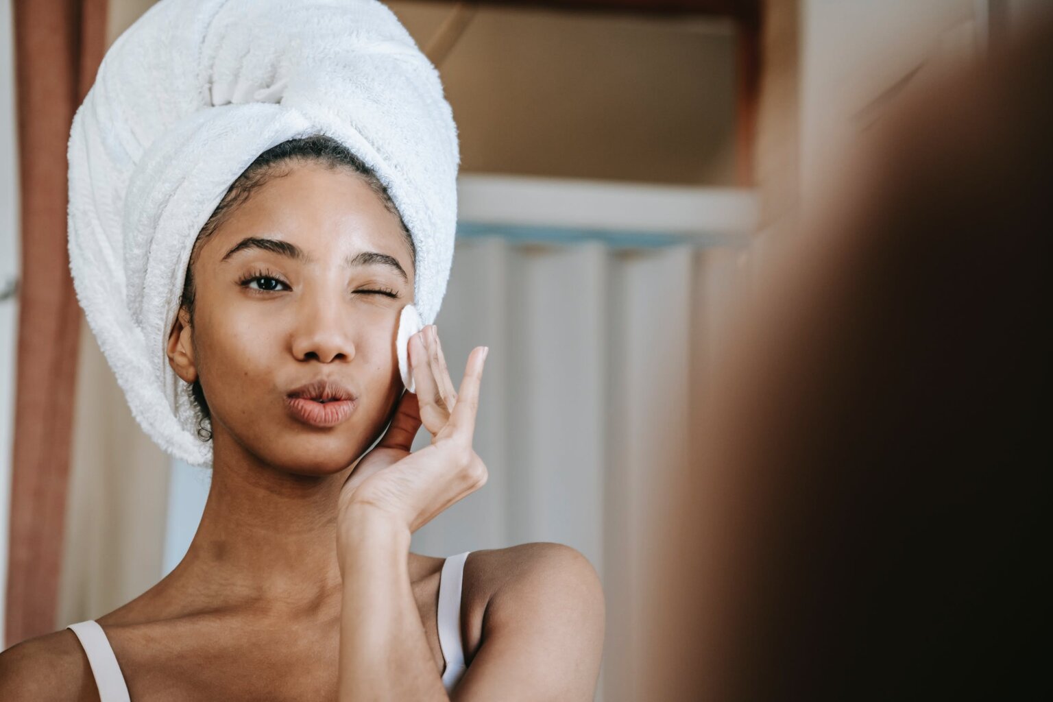 Woman cleaning skin with cotton pad