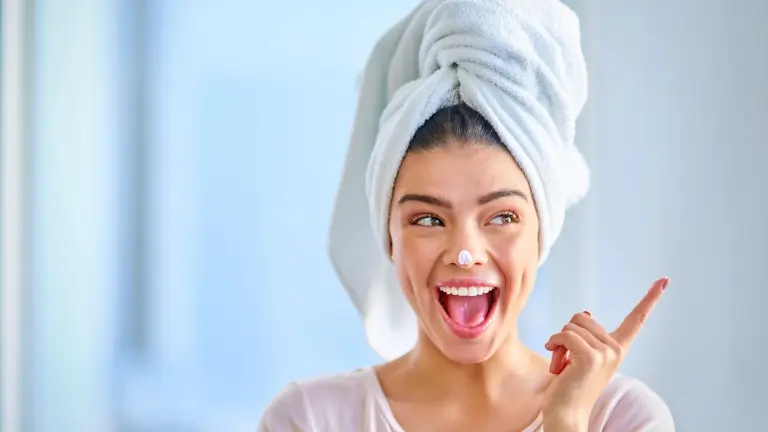 A lady with a towel on her head smiling